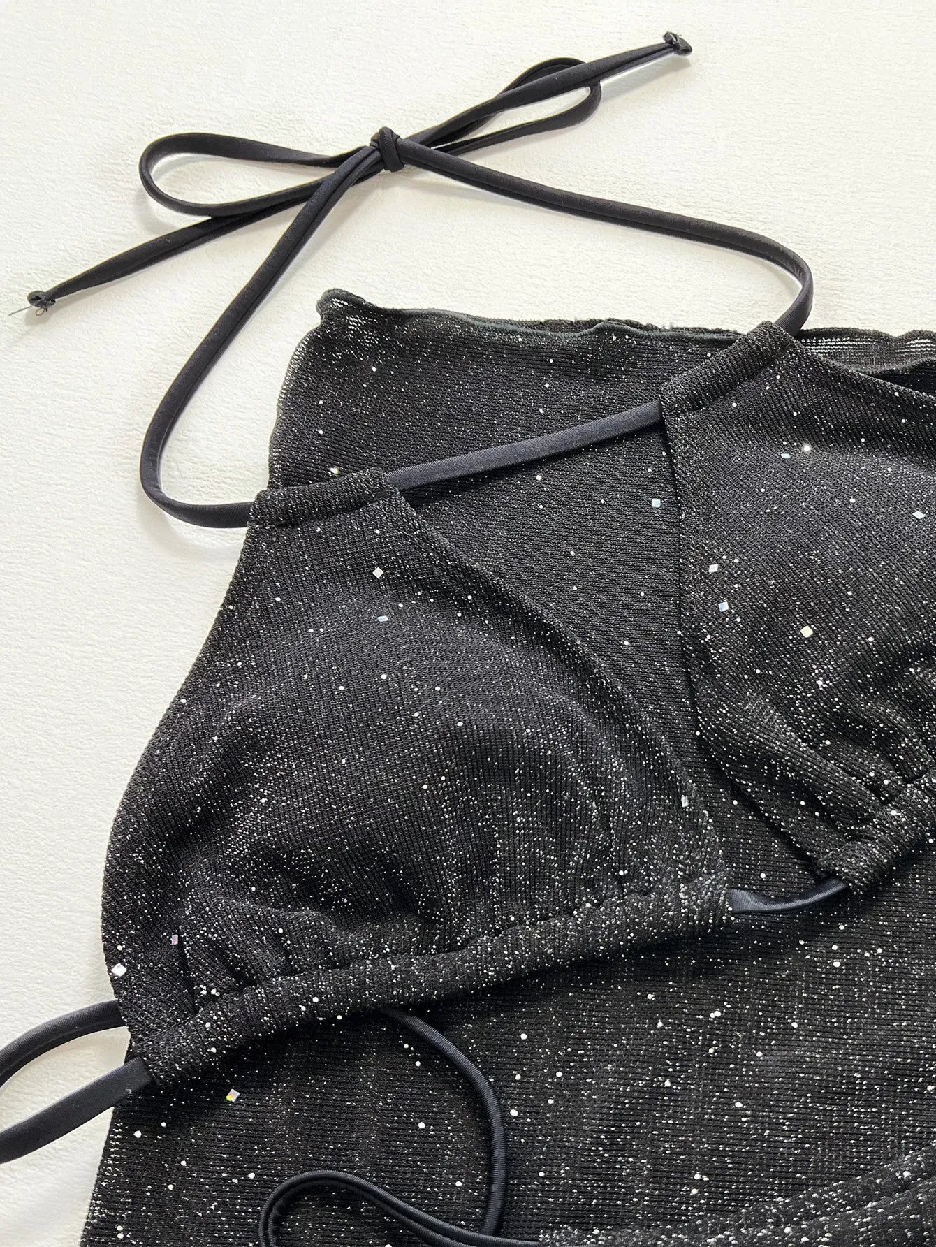 Black three-piece swimsuit bikini set with matching shorts on a mannequin