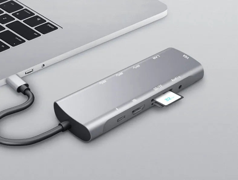 Grey aluminium USB-C docking station with HDMI, VGA, USB ports, and a short cable.