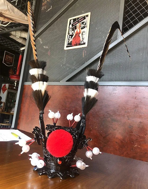 Zijin black crown and long feather decoration attached to a motorcycle helmet.