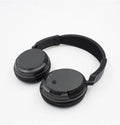 Black stereo wireless headphones with USB FM transmitter showing 30-metre range capability