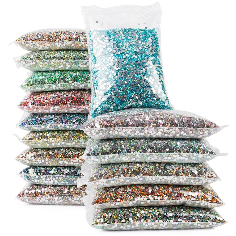 Assortment of multicoloured flat back resin rhinestones in various sizes for nail art and craft projects.