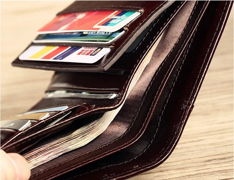 Men's brown leather bifold wallet open to show photo slot, card slots, billfold, and coin pocket.