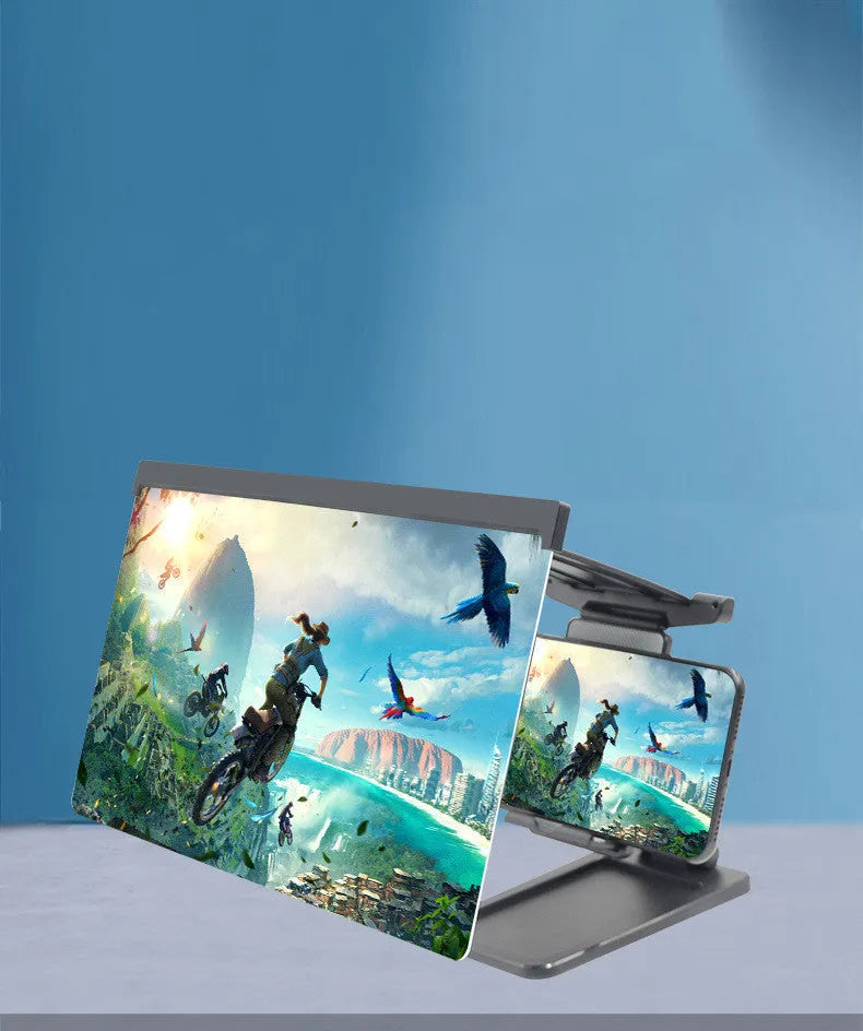 Black detachable mobile phone screen amplifier and folding holder shown on a desk next to a phone.