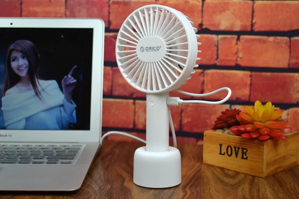 White ORICO FH1 portable USB rechargeable desk and handheld fan on a table