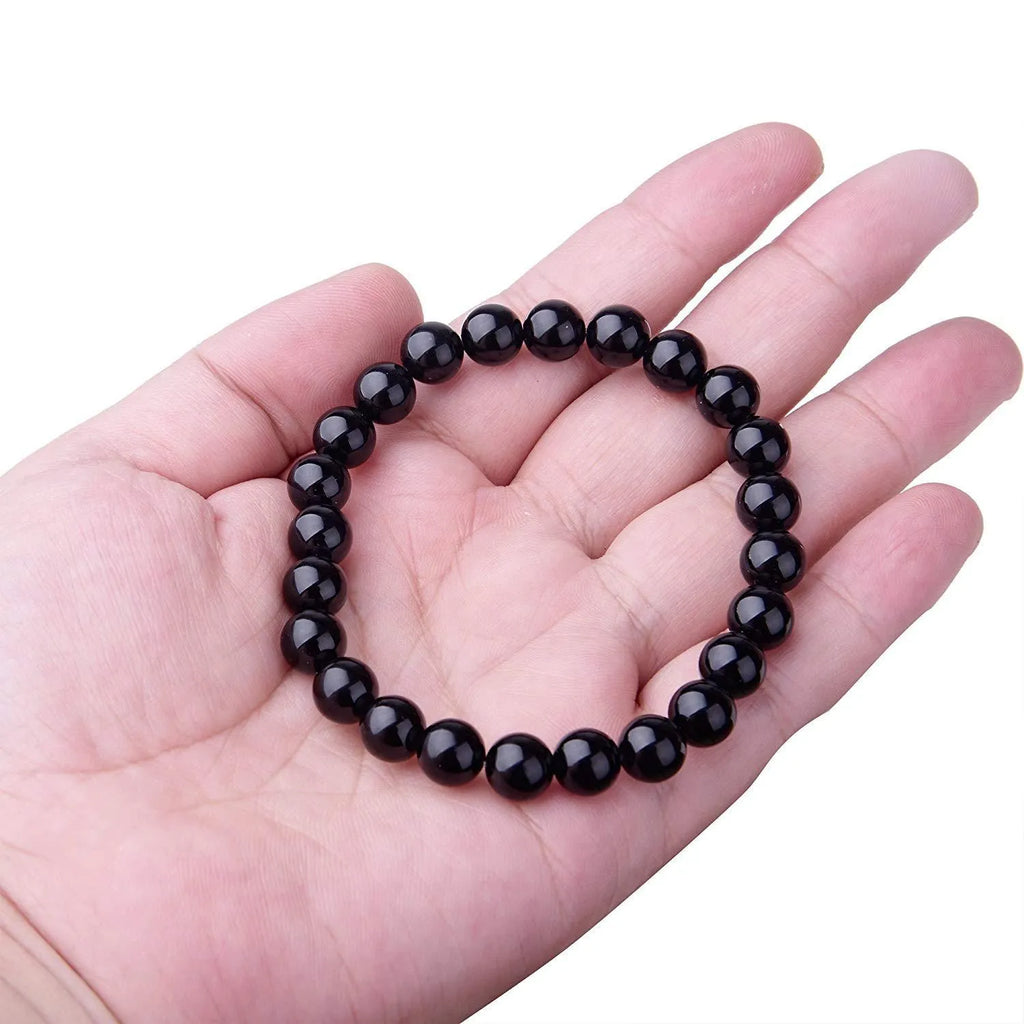 Black agate geometric bracelet with 8mm beads on a black elastic cord.