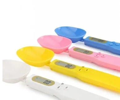 White electronic digital spoon scale with LCD display on a kitchen counter.
