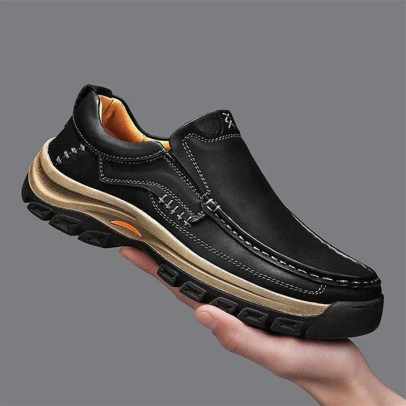 Men's black leather shoes with thick rubber soles and round toe design showing visible sewing thread construction