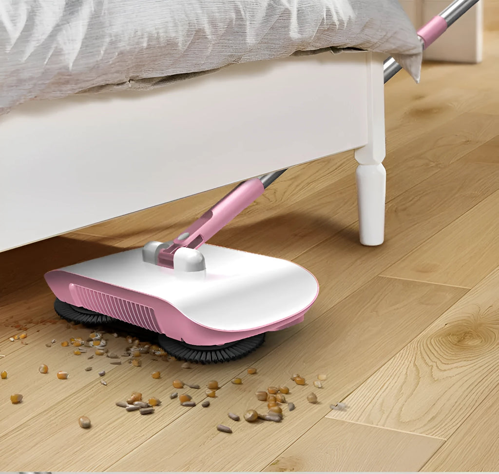 Pink hand push sweeper with rotating brush on floor shows broom dustpan mop all-in-one design