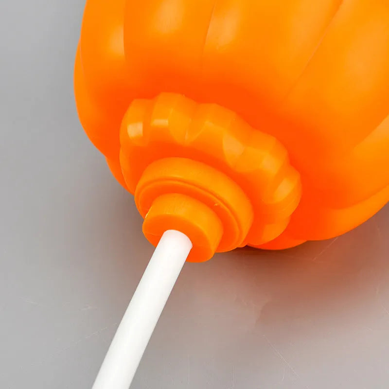 Plastic pumpkin-shaped decorative lamp with a USB cable, glowing either yellow or purple.