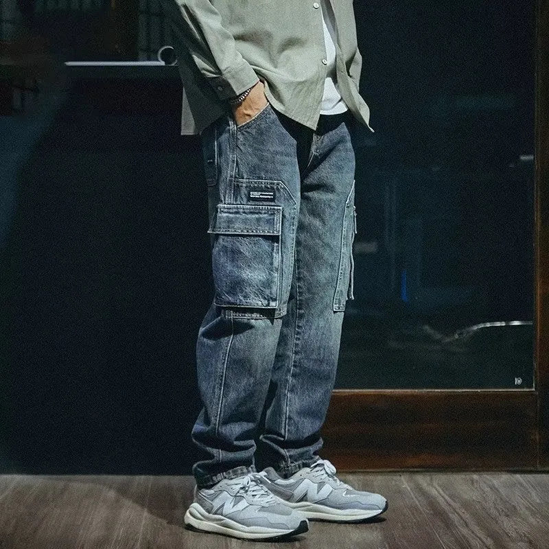 Man wearing blue loose straight-leg stretch denim trousers for a casual retro look.