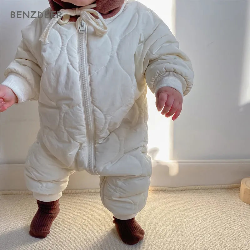 Baby padded quilted cotton kumpsuit in beige with attached hat and long sleeves, shown on a white background