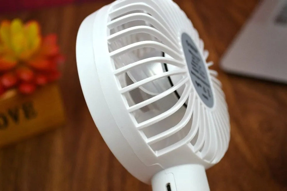White ORICO FH1 portable USB rechargeable desk and handheld fan on a table