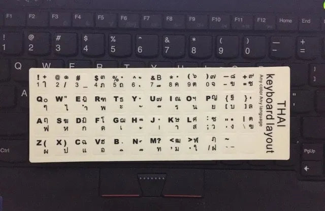 Yellow glowing keyboard stickers showing Arabic, Thai, Hebrew, French, Italian and German characters on PVC sheet
