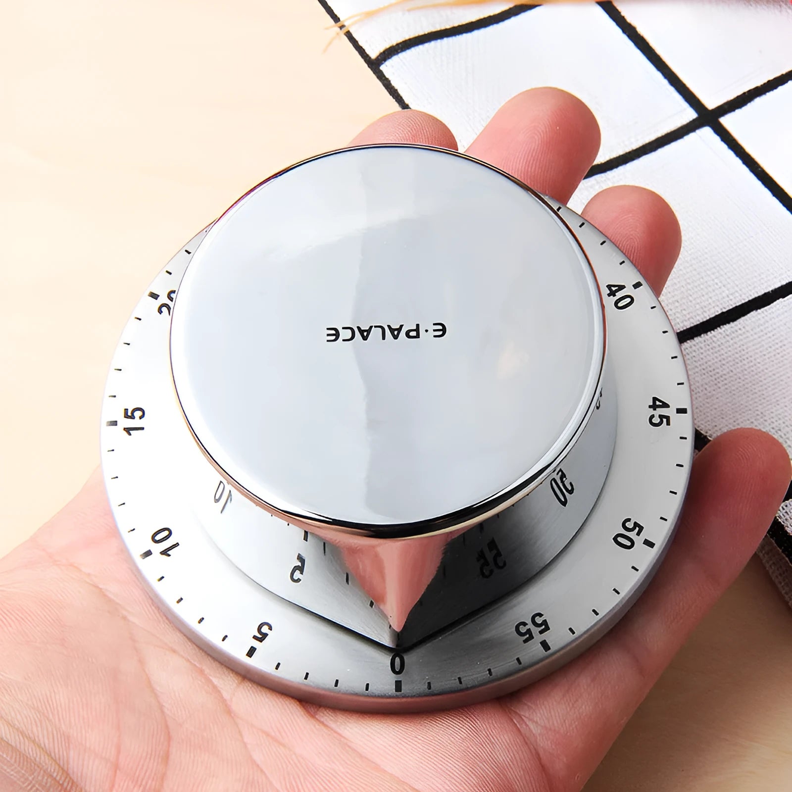 Green kitchen stainless steel mechanical timer with 60-minute dial on metal surface
