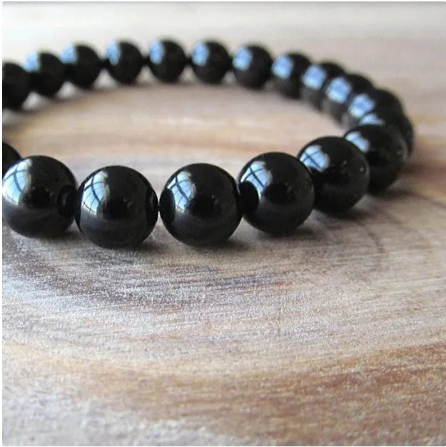 Black agate geometric bracelet with 8mm beads on a black elastic cord.