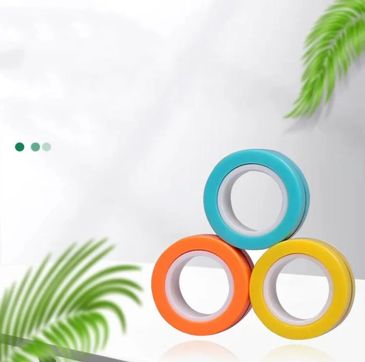 Plastic magnetic finger rotating ring spinner toy shown in multiple colours on a finger.