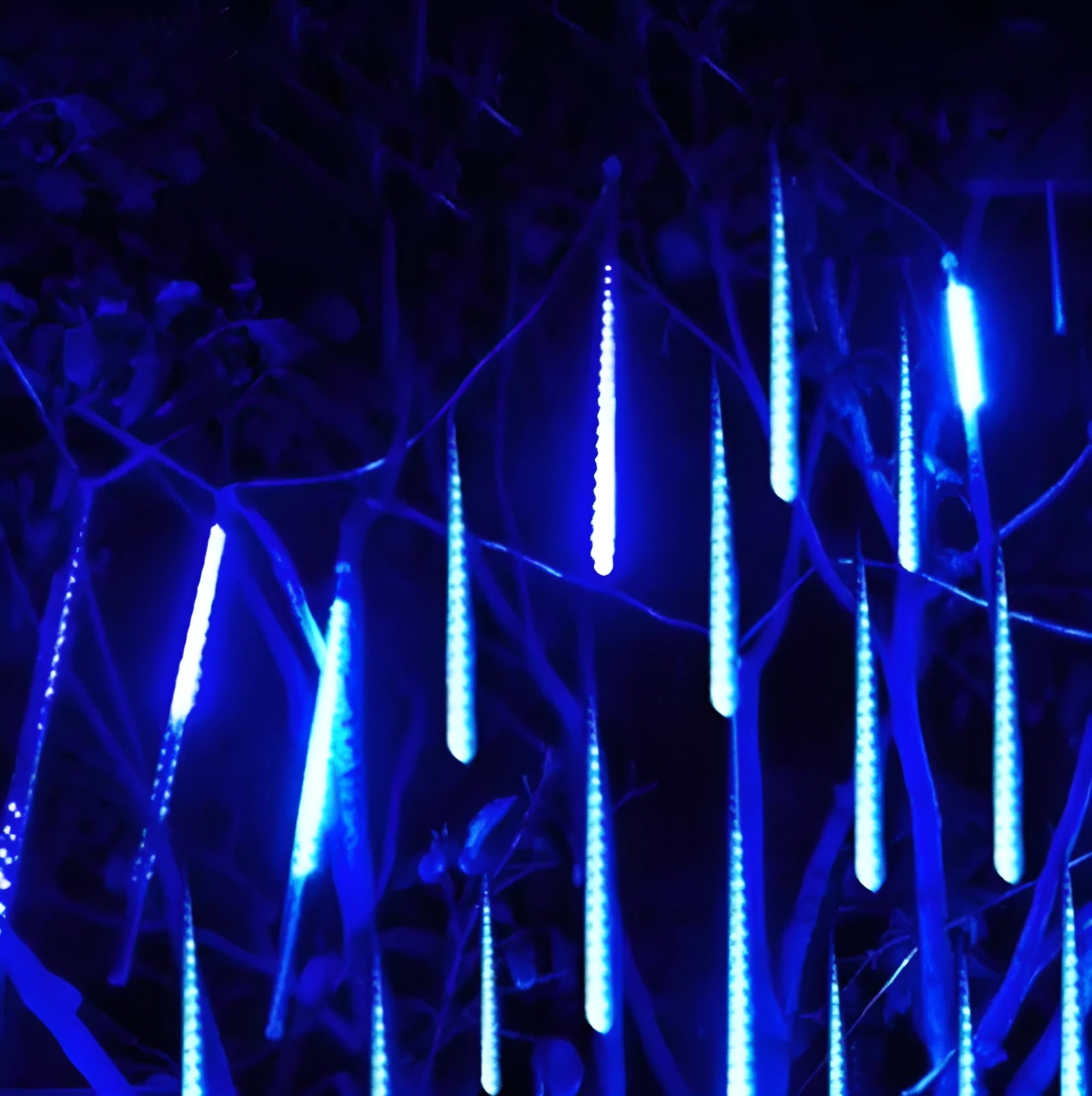 Waterproof LED meteor shower light set with 8 tubes in outdoor garden installation.