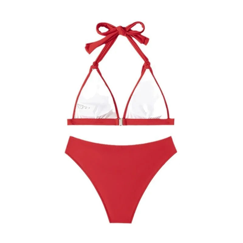 Red women's lace-up halterneck bikini with split shorts laid flat.
