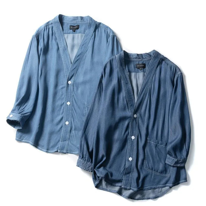 Men's dark blue V-neck denim coat with three-quarter sleeves showing loose fit and pocket detail