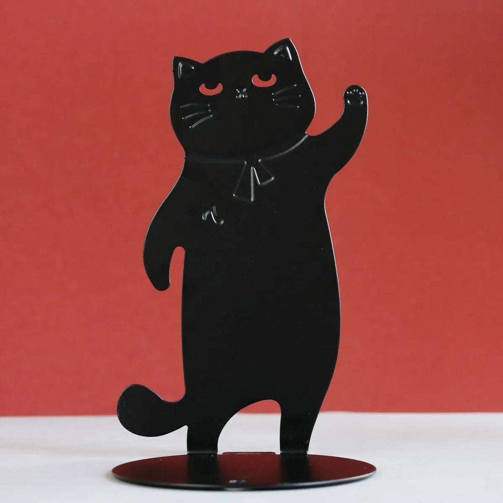 Set of two cartoon cat music themed iron bookends in black and white on a desk holding books upright