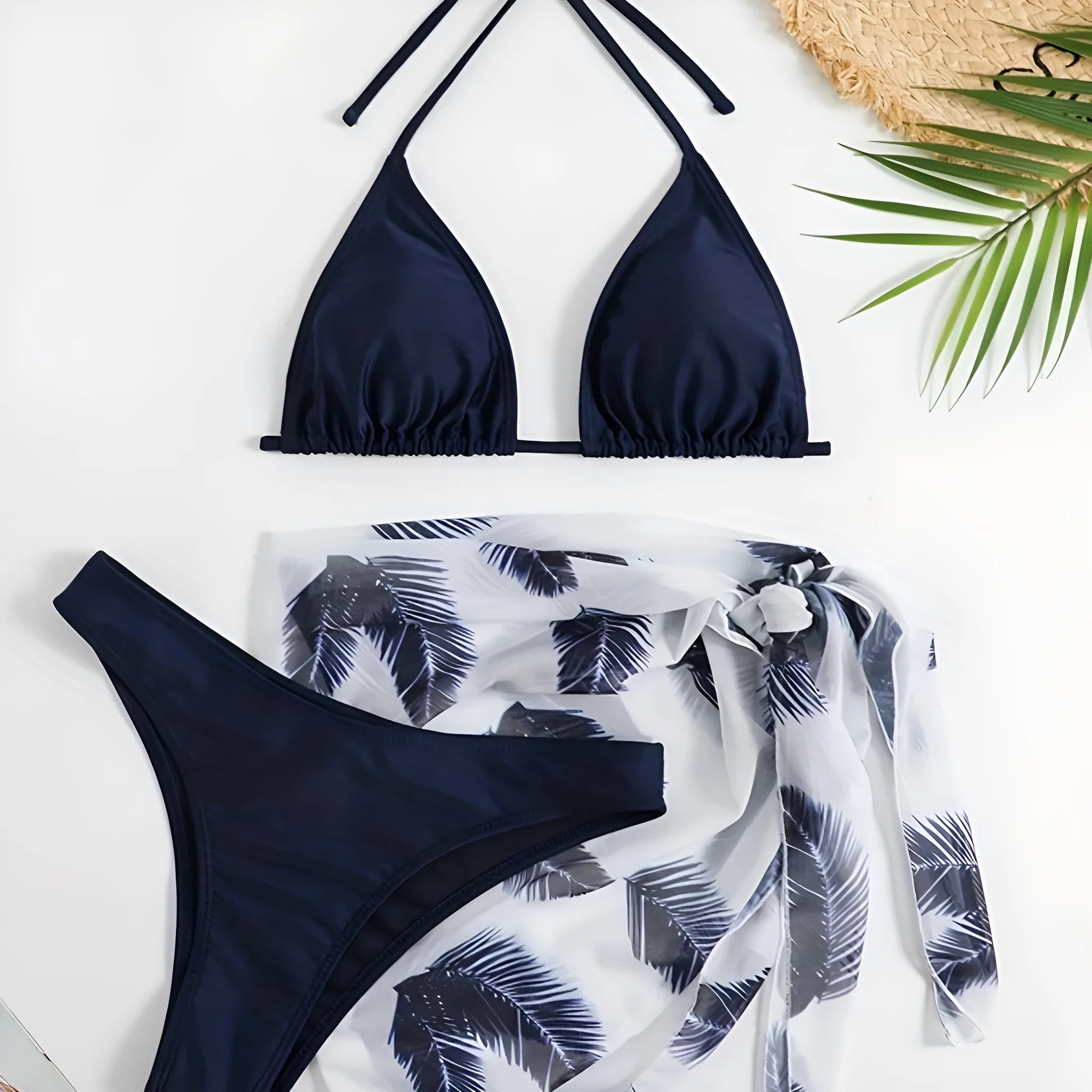 Women's orange three-piece bikini swimsuit set with a matching printed gauze skirt laid flat.