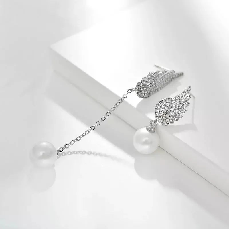 A pair of silver angel wing earrings with diamond treatment and gold-plated gemstone inlays on a platinum-colour finish.