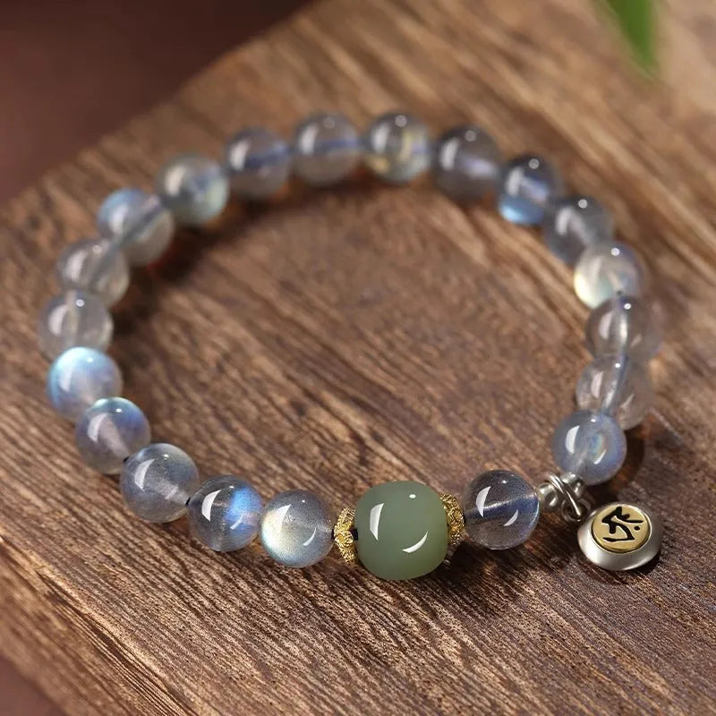 Close-up of a women's bracelet with 8mm moonstone beads and an electroplated Kwan-yin mouse charm.