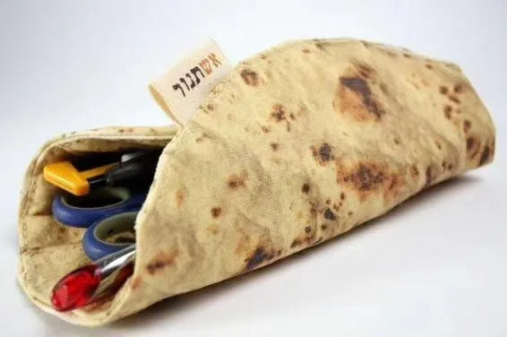 Fabric simulation burrito pencil case in clay oven rolls style, 22cm square, on a desk with pens inside
