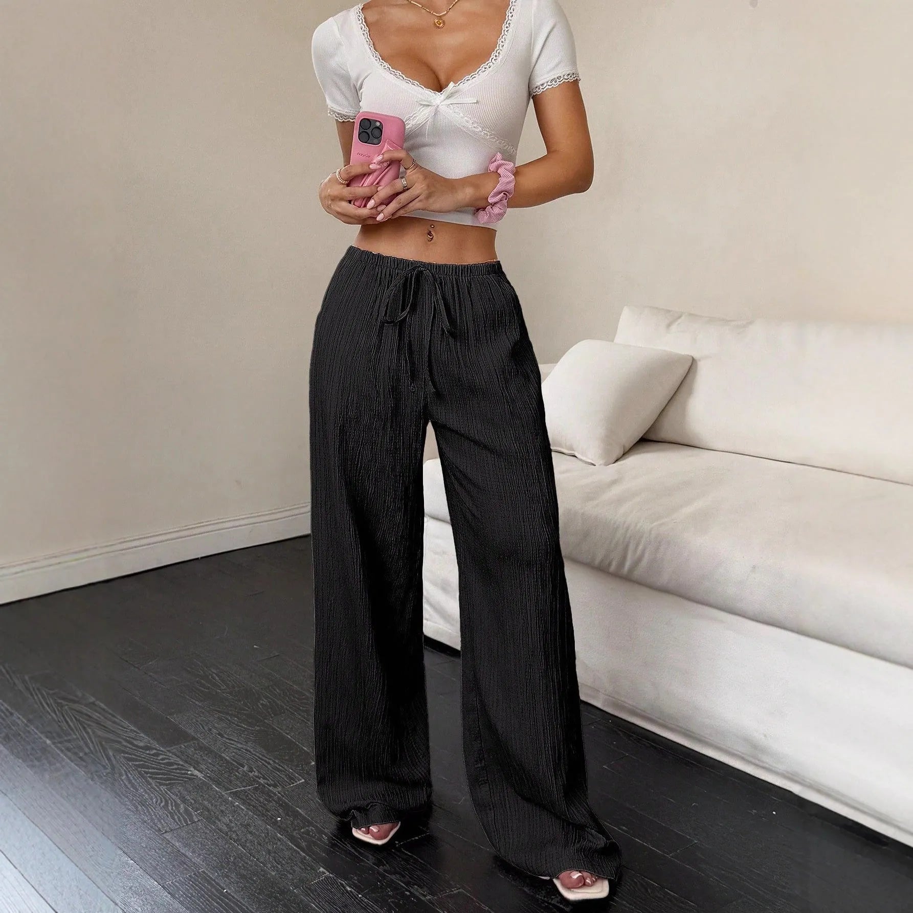 Women's black wide-leg trousers with a lace-up detail on the mid-rise waistband.