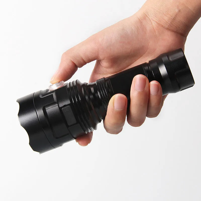 Black anodised aluminium tactical LED flashlight with a large head, shown with USB cable and yellow packaging box.