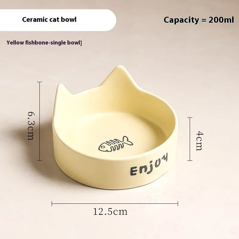 Porcelain cat bowl with cat ear handles in a wooden anti-tumble frame, showing paw print design.