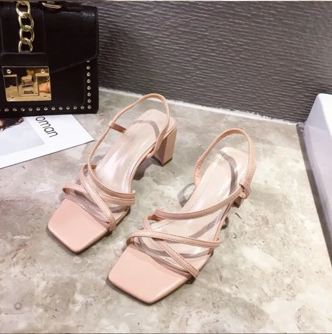 Women's white Roman sandals with a thick block heel over 8cm high, showing open back and side perforations.