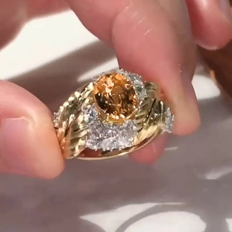 Gold-coloured embossed feather ring with geometric design and yellow zircon stone