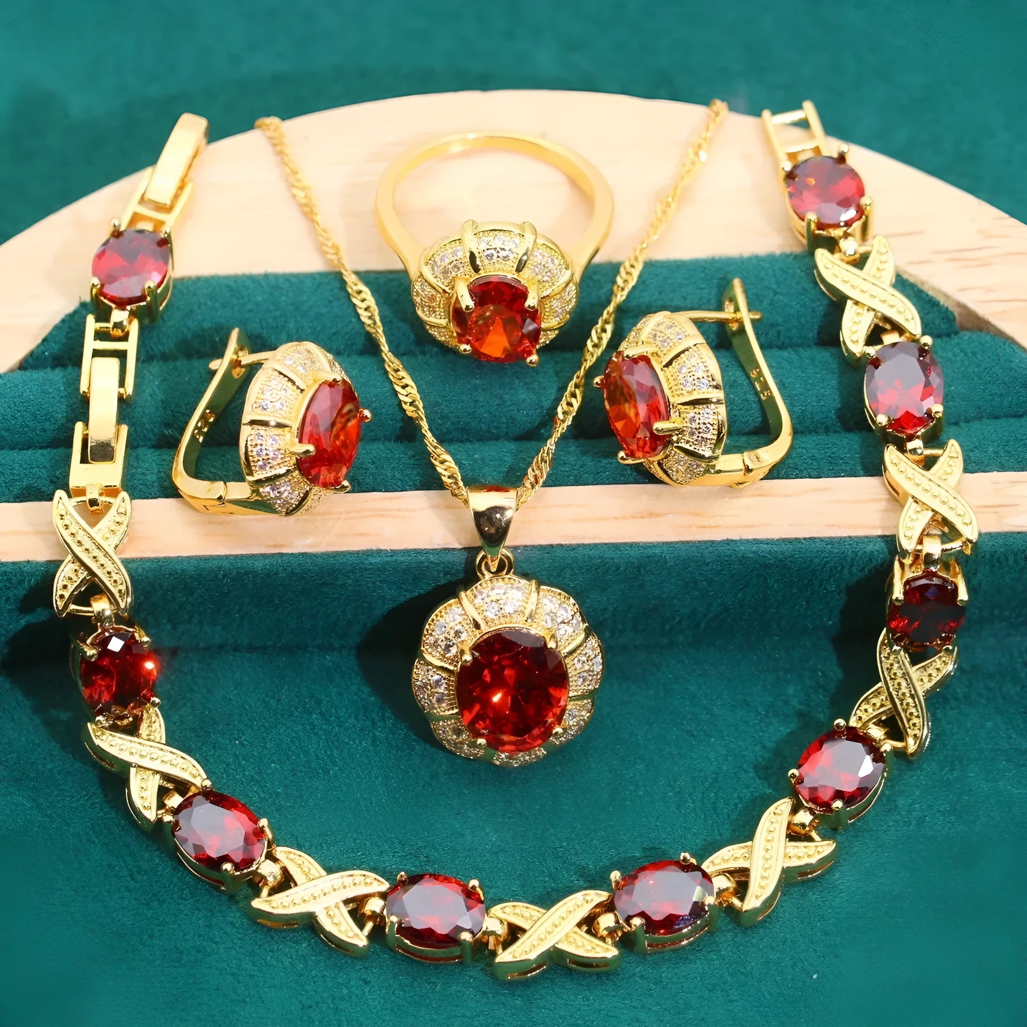 Gold plated necklace, earrings, ring, and bracelet set with blue cubic zirconia stones on a grey background.