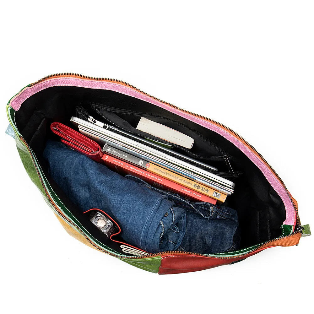 Brown cowhide leather crossbody travel bag with stitching, shown holding a laptop and A4 magazine.