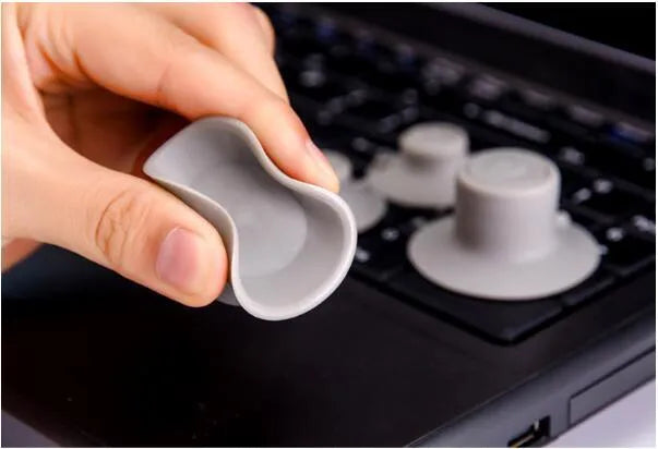 Grey durable plastic laptop cooling pads, two large and two small, on a desk.