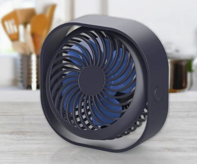 Pink USB desk fan with 360-degree rotating head on a white desk.