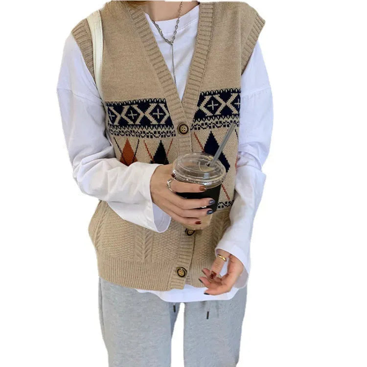 Woman wearing a loose khaki diamond plaid sleeveless cardigan top over a white t-shirt.