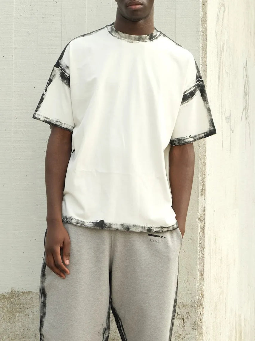 White casual short sleeve top with draped neckline and printed pattern on a hanger.