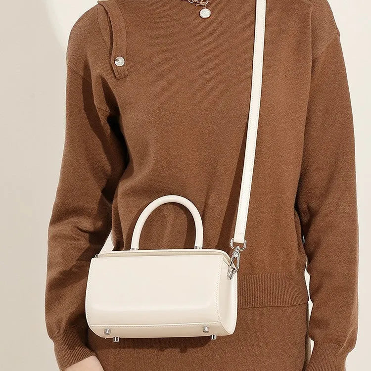 Structured leather women's crossbody bag in a clamshell design, shown in one of four colour options.
