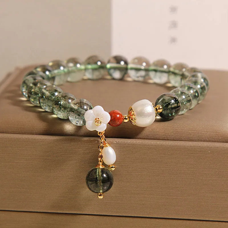 Green phantom quartz crystal bracelet with shell flower charms on wrist