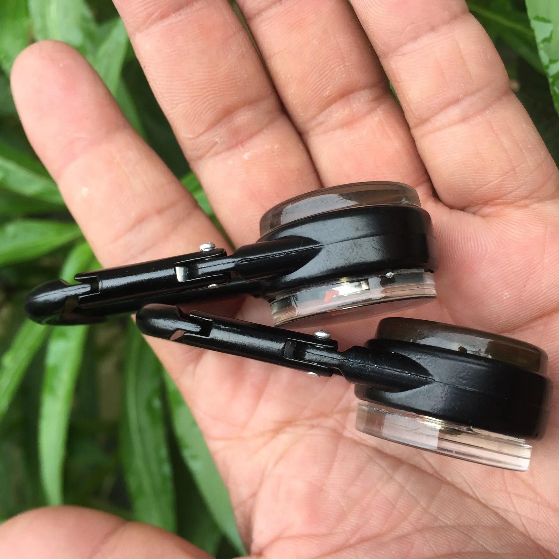 Black zinc alloy camping carabiner with built-in compass and thermometer, showing double-sided button and 65mm size.