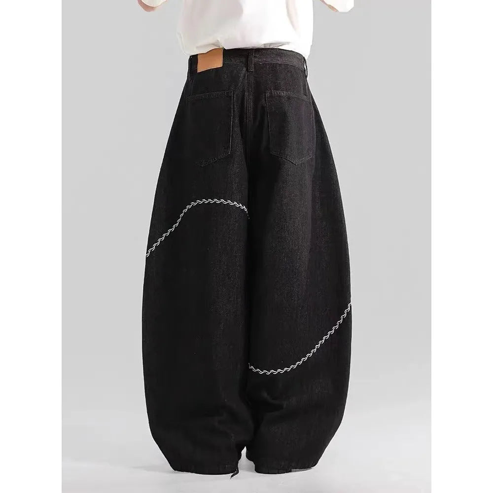 Black straight-leg denim trousers with a mid-waist fit and zip fly, laid flat.
