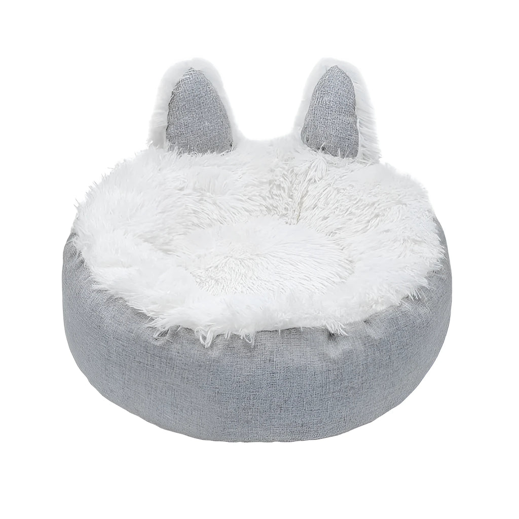 Blue plush faux fur circular cat bed with raised sides on a wooden floor