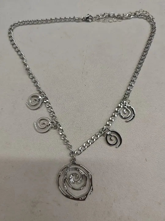 Geometric spiral donut jewellery set showing necklace, bracelet, and earrings in gold electroplated finish