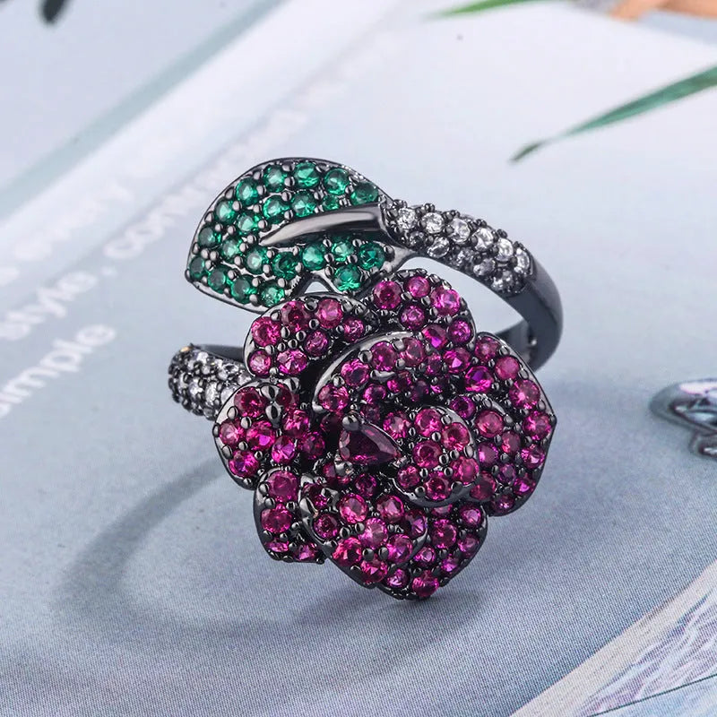 Geometric black gold ring with red simulated corundum centrepiece in flower design