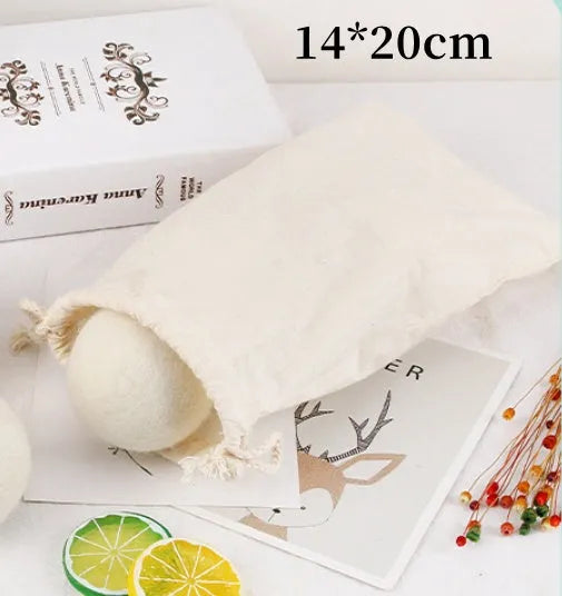 Handmade natural wool felt drying ball for laundry next to a plain cotton storage bag.