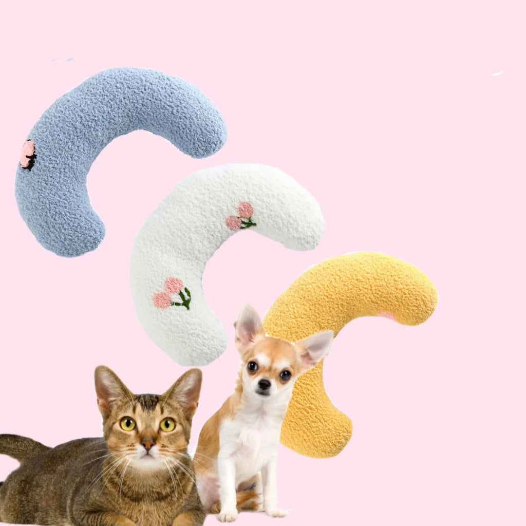Small white half-donut U-shaped plush pillow for a cat or small dog on a carpet