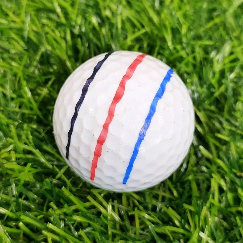 Plastic golf ball alignment scriber tool with drawing pens on a green.