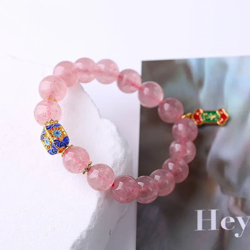 Pink strawberry quartz crystal bracelet with hand-woven beads, Ruyi charm, and letter charms.